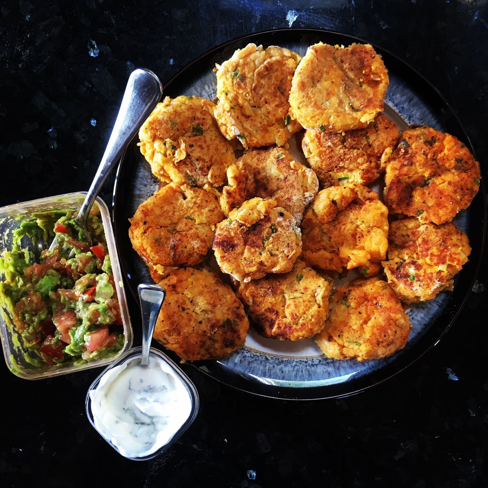 Sweet potato fish cakes with guacamole and minty yoghurt served with lots of tomatoes